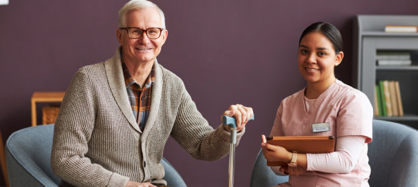 and elderly man and a female caregiver sitting