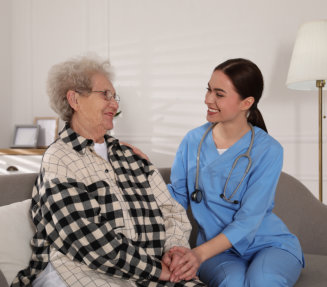 an elderly woman and a female caregiver looking to each other