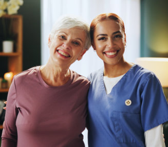 A female and an elderly woman smiling together