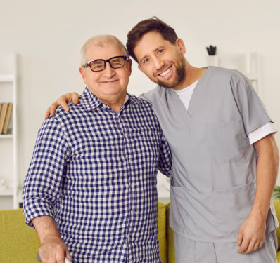 an elderly man and a male caregiver smiling together