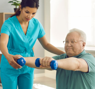 A female caregiver assisting an elderly man lifting weights